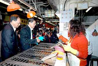 Hong Kong's Secretary for Health, Welfare & Food Dr Yeoh Eng-kiong (middle) reminded live-poultry stall operators to comply with the hygiene requirements to guard against avian flu.