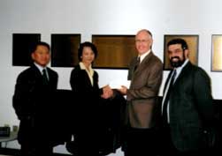 Ms.Christine Leung, presents a cheque for $23,000 to the Associate Dean of Administration, School of Business of the University of Alberta, Professor Tom Scott (2nd right). 