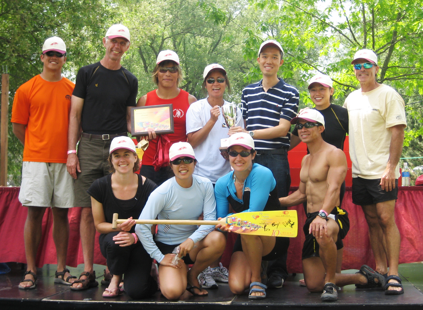 The Deputy Director of the HHKETO, Mr Francis Ho (back row, third right), presents the special "Hong Kong 10th Anniversary Cup" to Outer Harbour Dragonboat Club  "Mayfair Predators", the winning team of the International Mixed Championship Race, at the 19th Toronto International Dragon Boat Race Festival.