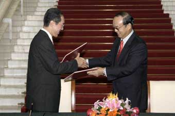 China's Vice-Minister of Commerce, Mr An Min (right), and HK's Financial Secretary, Mr Henry Tang, exchange the signed document on the arrangement to provide further liberalisation measures on trade in goods and services under the second phase of the CEPA II.