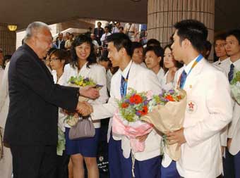 Mr Tung (left) shakes  hands with the table tennis doubles silver medal winner, Mr Li Ching. 