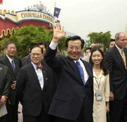 Accompanied by Chief Executive Donald Tsang (2nd left), Vice-President Zeng Qinghong greets the public in front of the Cinderella Carousel at the opening of Hong Kong Disneyland.