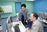 Simon Galpin (right) of InvestHK receives a brief by Day and Night Securities Limited on the company's operating system in which securities are traded.